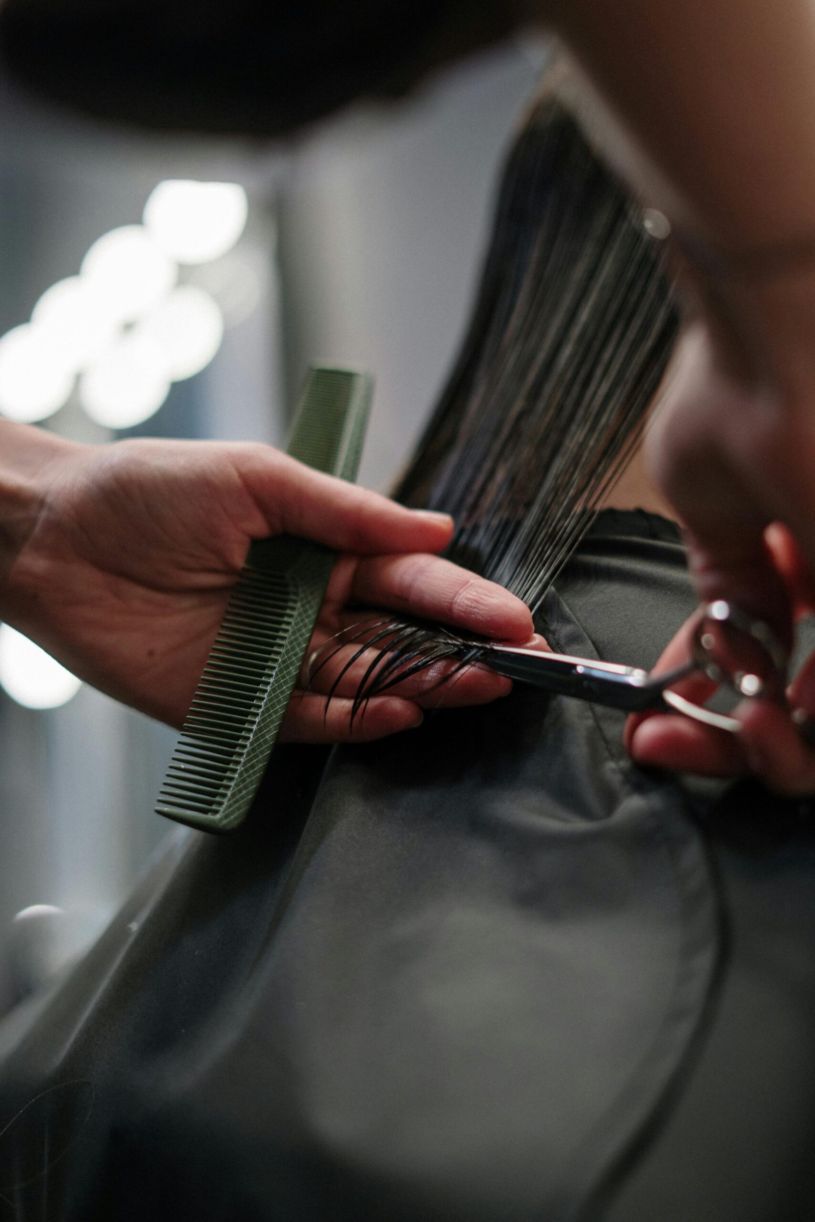 Close-up of hairstylist cutting wet hair in a salon.